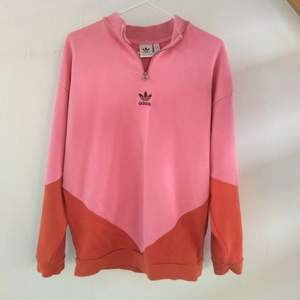 Asball orange och rosa tröja från adidas med quarterzip. Jättebra skick då den tyvärr inte kommer till användning. 
