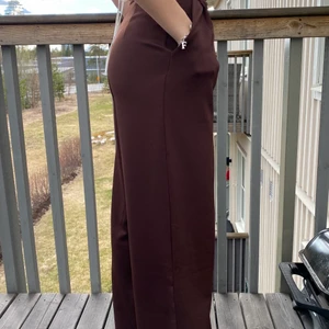 Bruna kostymbyxor - strl 34 - Kostymbyxor från h&m. Använda 1 gång. Vid modell, högmidjae och fickor. Min syster på bilden är 167 cm så dem är långa i benen. 🤎
