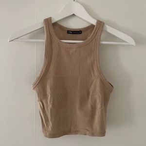 Zara topp - Topp från Zara i beiget ribbat material. Storlek M men passar även mig som är S. Aldrig använt. Säljer för 50kr + frakt (frakten kan variera utöver skrivet pris).