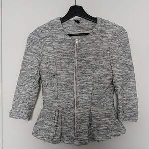 Grey jacket with peplum silhouette, sleeves have a 3/4 length