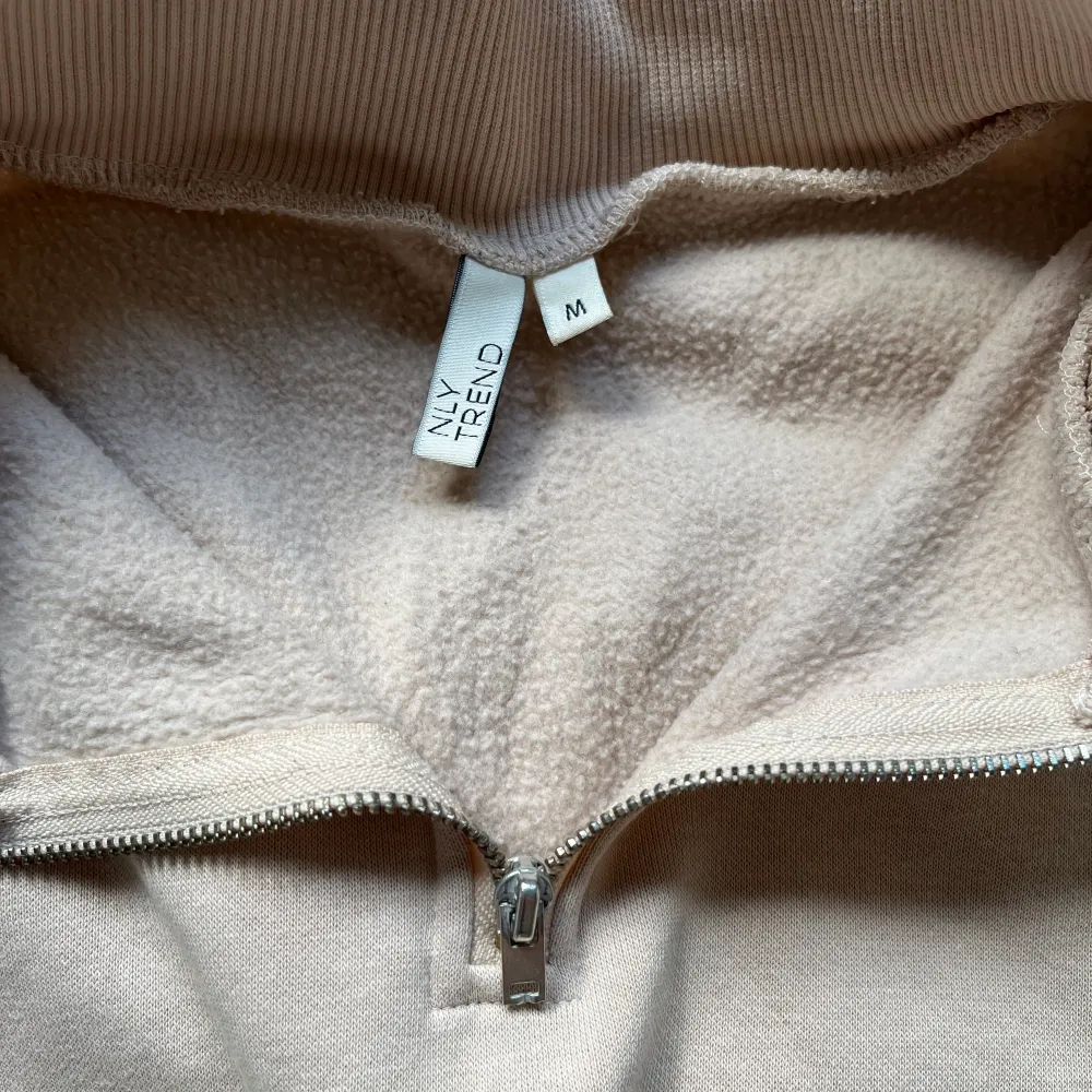 Beige half zip up hoodie från Nelly. Köpt för länge sen men sparsamt använd. Storlek M men liten i storlek. Mjukt material inuti.. Tröjor & Koftor.