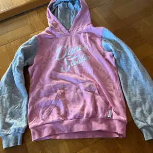 Rosa hoodie med grå ärmar från Soc 