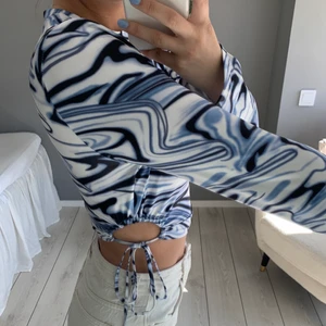 Mönstrad långärmad topp - Långärmad mönstrad topp med knytningar i sidan. Endast använd en gång. Frakt tillkommer på 66 kronor:)