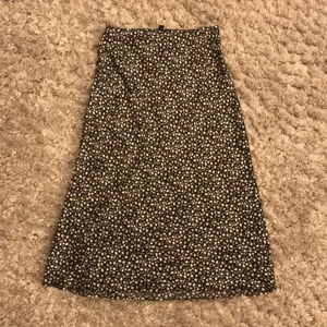 Lång somrig kjol  - Medel lång satin kjol med tryck av små gulliga blommor säljs 🌸🌸 Dem är svarta med små blommor på sig i färgerna ljus rosa och vit. 💗💗Passar perfekt till på sommaren och säljer då den har blivit för liten🍀🍀 Är i bra skick och har inga skador eller nått🧚🏼‍♀️🧚🏼‍♀️