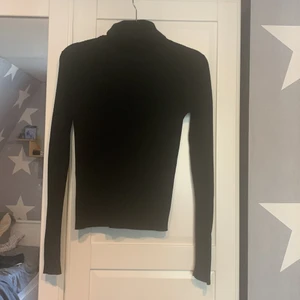 Svart lågärmad polo tröja  - Säljer dena svarta ribade polotröja för att den inte kommer till användning använt några få gånger och är i bra skick