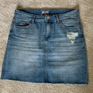 Blå jeanskjol Tommy Hilfiger - Väldigt fint skick. Nypris 399kr. Midja 41 cm, höft 52 cm, längd 44 cm.