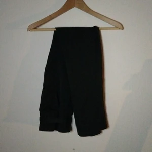 Svarta byxor från h&m - Ett par svarta byxor från h&m som knappt blivit använda eftersom jag hade de som fin byxor. Har dock växt ur de nu. Jättebra skick och kommer med ett belte som man behöver knyta. Den stängs med två krokar och en knapp på insidan.