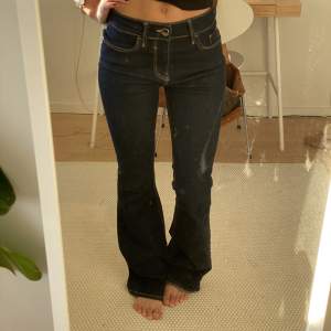 Mörkblå Bootcut jeans med midwaist. Midjemått: 76cm, Innerbenslängd: 86 cm. Lite slitna längst ner. Fraktar för 59kr eller möts upp i Lund.