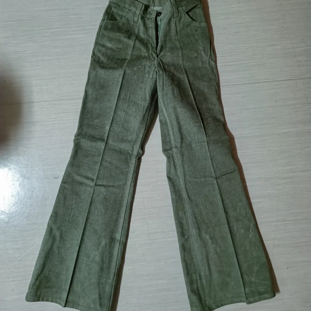 Säljer dessa fina högmidjade byxor som gjordes på 70-talet och aldrig har använts! De är 64 cm i midjan och 80 i längden, vilket motsvarar typ xs, men har även massa andra storlekar så det är bara att höra av sig!💗. Jeans & Byxor.