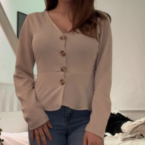 Blus med knappar  - Fin man kan använda det som en tröja och man kan ha ett linne under och öppna den  Det är väldigt fina knappar på den