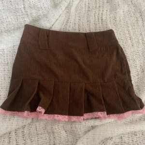 Gullig kjol - Jätte gullig brun kjol med rosa detaljer, köpt second hand, tyvärr ingen lapp så har ingen aning vilket märke den är ifrån.