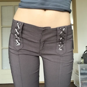 Y2k byxor - Gråa y2k bootcut byxor 🧚‍♂️Dom har en liten fläck på benet men syns knappt. 83.5 cm runt midjan, 72 cm innerbenslängd. Stretchigt material 📿Jag är 176 cm och har W29 i jeansstorlek (dom är för korta för mig) 💝 Endast frakt ✨Använd gärna köp nu-funktionen 💛
