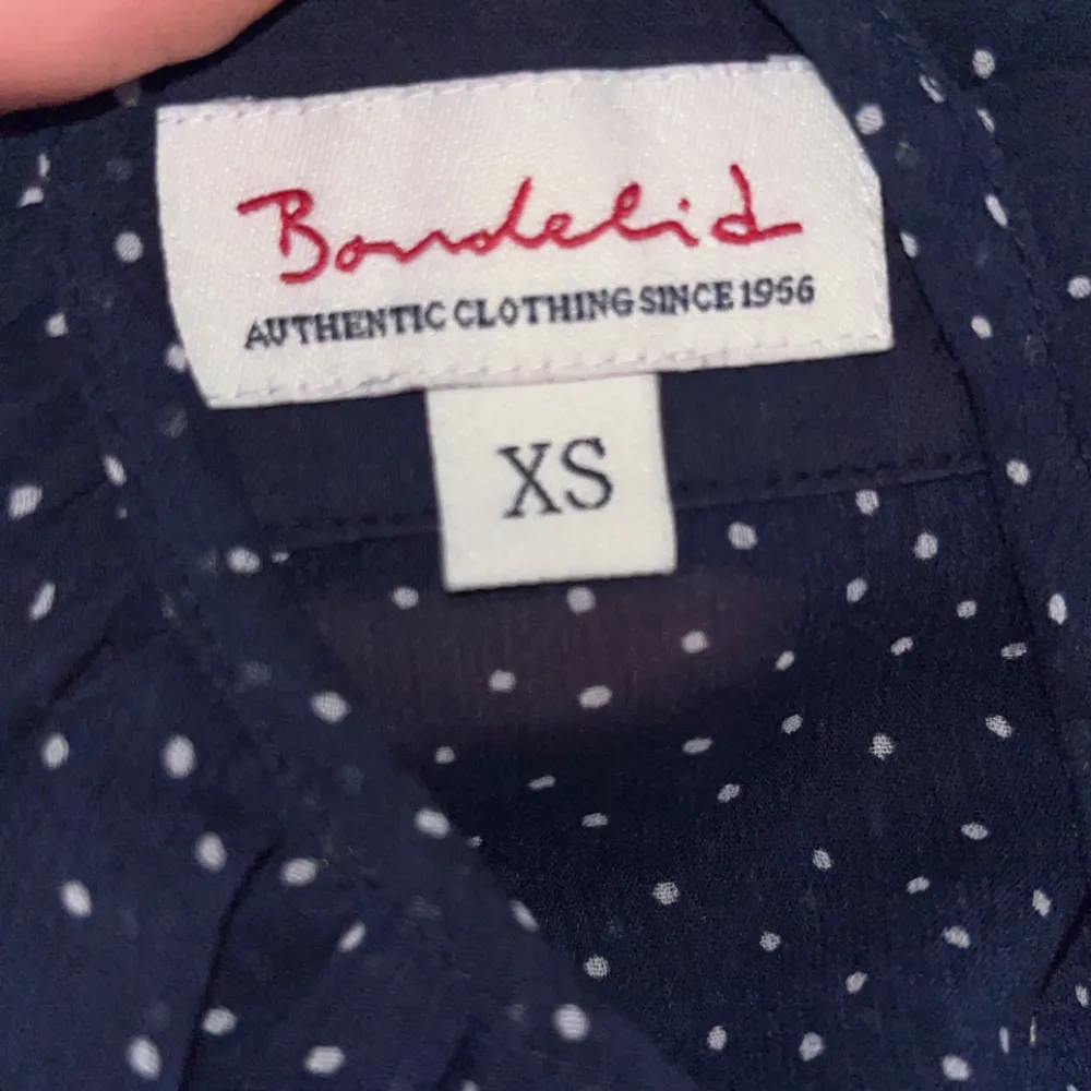 En blå topp med vita prickar. Märket är Bondelid. Super söt och bra kvalitet. Använt bara 2 gånger så den är som ny! Det är en XS men passar som en Medium.. Toppar.