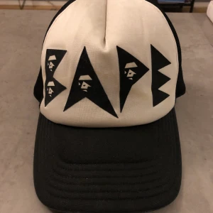 Bape keps - Sjukt snygg truckerkeps från BAPE. Den är välanvänd och den vita delen är inte kritvit längre men har mycket kvar att ge!