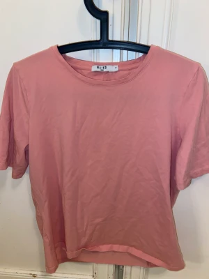 NA-KD  - En T-shirt från NA-KD i storlek M den är smutsrosa i färgen. Man får stå för frakten själv och pris för frakten kan vi diskutera🥰