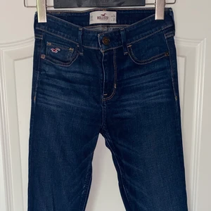 Hollister & Co jeans. Låg/mid waist med detaljer  - Skinny jeans från Hollister i superbra skick med low rise👖 Säljer pga för små för mig. Storleken är 0R 24/31 i klassisk dark wash tvätt/färg.    Jeansen kan klippas och bli snygga shorts istället också👌🏼☀️