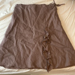 H&m kjol från 20-talet - En vin lila kjol från 20-talet. Man kan knyta på sidan ifall den är Förstorare. 