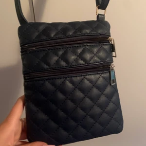 Liten väska  - Säljer en liten skinnväska då den inte används. Märket är okänt, den har ett justerbart axelband. Supergullig väska med flera fack. Frakt på 66kr tillkommer💕