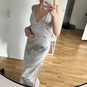 Silvrig satin klänning / balklänning - Superfin maxi/bal klänning. Storlek 40 men passar 38/M (jag är S, stor på mig). Små skav, se bild 3. Inget som syns väl.