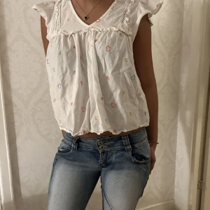 Söt mönstrad blus  - Jätte söt fin vit blus med färglagt mönster. Mönstret består bla av små 💕 hjärtan. Jätte fin att ha till i sommar men även nu som vardagsplagg😌
