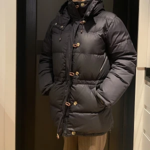 Boomerangjacka - Äkta boomerang dunjacka, marinblå i storlek S. Stängs med dragkedja, sidofickor och innerficka. Dragsko i midjan. Använd men i gott skick, lite nött på vissa ställen. Kan Behövas tvättas. Nypris 5999:-