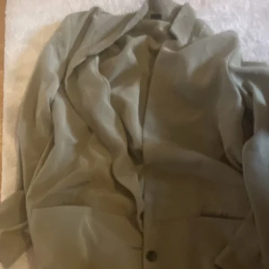 Khaki  - En khaki lång kappa med knappar oanvänd finns fler bilder s