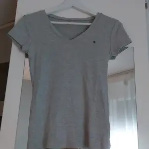 En grå tommy hilfiger V-neck t-shirt - Lt grey htr. Normal pris 241:- mitt pris 80:- Köparen står för frak🩶