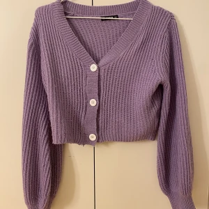 Lila cardigan - Gullig lila stickad cardigan men vita knappar Säljs för jag inte längre använder den (frakten ingår ej)