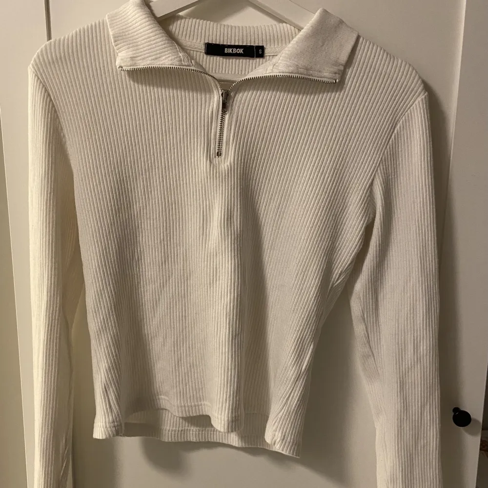 Det är en vit ribbad långärmad tröja med dragkedja där fram.  Köpt för längesen men knappt använd  Kan mötas upp i Stockholm . Toppar.