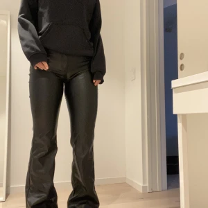 Byxor i skinimitation  - Utsvängda byxor i skinimitation. Aldrig använda!!   Jag är 167cm lång och har storlek S