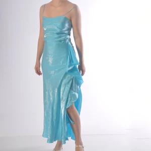 Turkos långklänning i satin med slits - Turkos satin långklänning med snygg slits. Står ingen storlek men passar nog bra på en S/36 - M/38.   Modellen är 171 cm och bär klackskor.  (Fler bilder finns! - Skriv isf) Fransk design