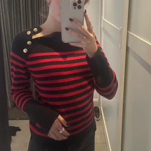 Randig tröja från Zara - Jättefin randig tröja i röd och mörkblå från Zara med guldknappar som du kan välja om du vill ha öppna eller inte. Storlek M, endast använd 2 gånger. ❤️