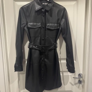 Skin Klänning / Jacka  - Säljer denna skinklänning/jacka från NA-KD i storlek 36. Plagget har utgått ur sortimentet och köptes in för 699kr, säljes nu för 290kr. Fraktas på köparens bekostnad. 