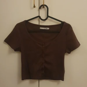 Brun croppad tröja - Aldrig använd Lite stor i storleken. Frakten är inräknad i priset!!