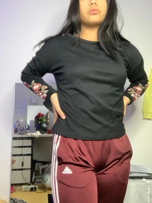 Svart tröja  - Svart tröja med blommor på armarna, finns även en i rosa