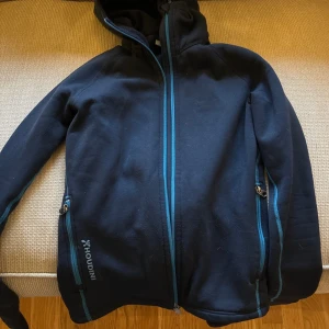 Houdini Fleece - Mörkblå Houdini fleece med ljusblå detaljer. Använd men i bra skick. Strl Xs men funkar även som S. Nypris 2200 kr, mitt pris 800 kr. 