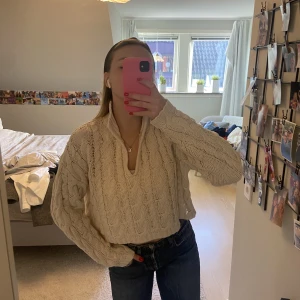 Stickad tröja - Beige stickad tröja som sitter lite croppad i modellen och som går att ha på många sätt. Den går även att ”knäppa” som på bild 3. 