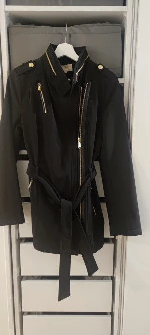 Kappa Michael Kors - Svart kappa från Michael Kors. Lätt fodrad, passar vår och höst. Storlek S. Fink skick. guldfärgade detaljer.