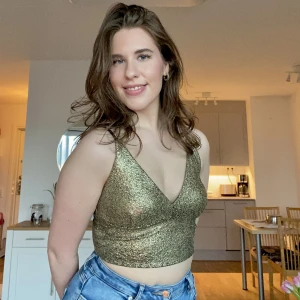 Guldig topp strl S - Guldig läcker topp från BikBok i storlek S, aldrig använd (bara testad) så den har lappen kvar. 🌟Den har justerbara axelband och är i stretchigt material, vilket gör att den är väldigt skön att ha på sig 🥰. Perfekt till en svart kjol och svarta klackar ✨