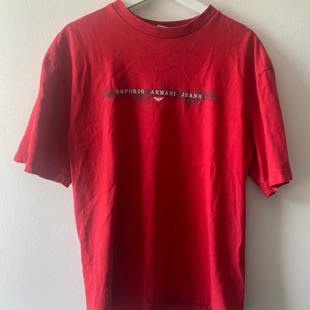 En röd vintage t-shirt från Emporio Armani Jeans med oversize passform. Sitter svinsnyggt och passar perfekt nu till sommaren. Köparen står för frakten, önskas fler bilder är det bara att höra av sig!. T-shirts.