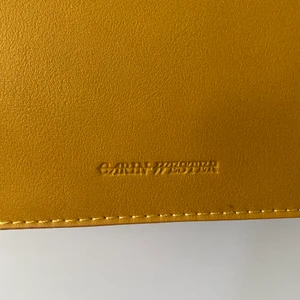 Carin väster väska i fake skinn - Senaps gul fake skinns väska från Carin Wester. Ny skick då aldrig andvänd! Det ingår två axelremmar ett senaps gult band som kan variera längd och ett svart bredare band i tyg. 