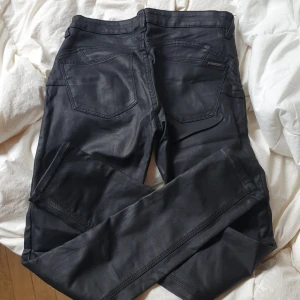 Mango Jeans Leather like - Slim fit Low waist Material: 76% viskos, 21% polyamid, 3% elastan