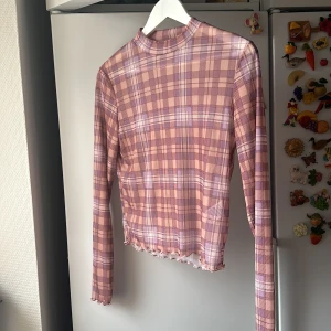 Rutig meshtop - Ginghamrutig meshtop från Bikbok helt oanvänd med mycket stretch   Meshad men mönstret gör att den inte upplevs lika genomskinlig   Söt detalj med vågsömn vid kanten och ärmarna 