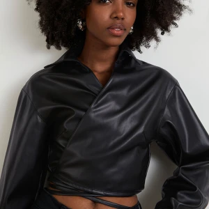 Gina tricot  - Omlott shirt i skinnimitation från Gina Tricot, helt ny med prislappen kvar. Nypris var 399kr, helt slutsåld idag. Storlek 38.