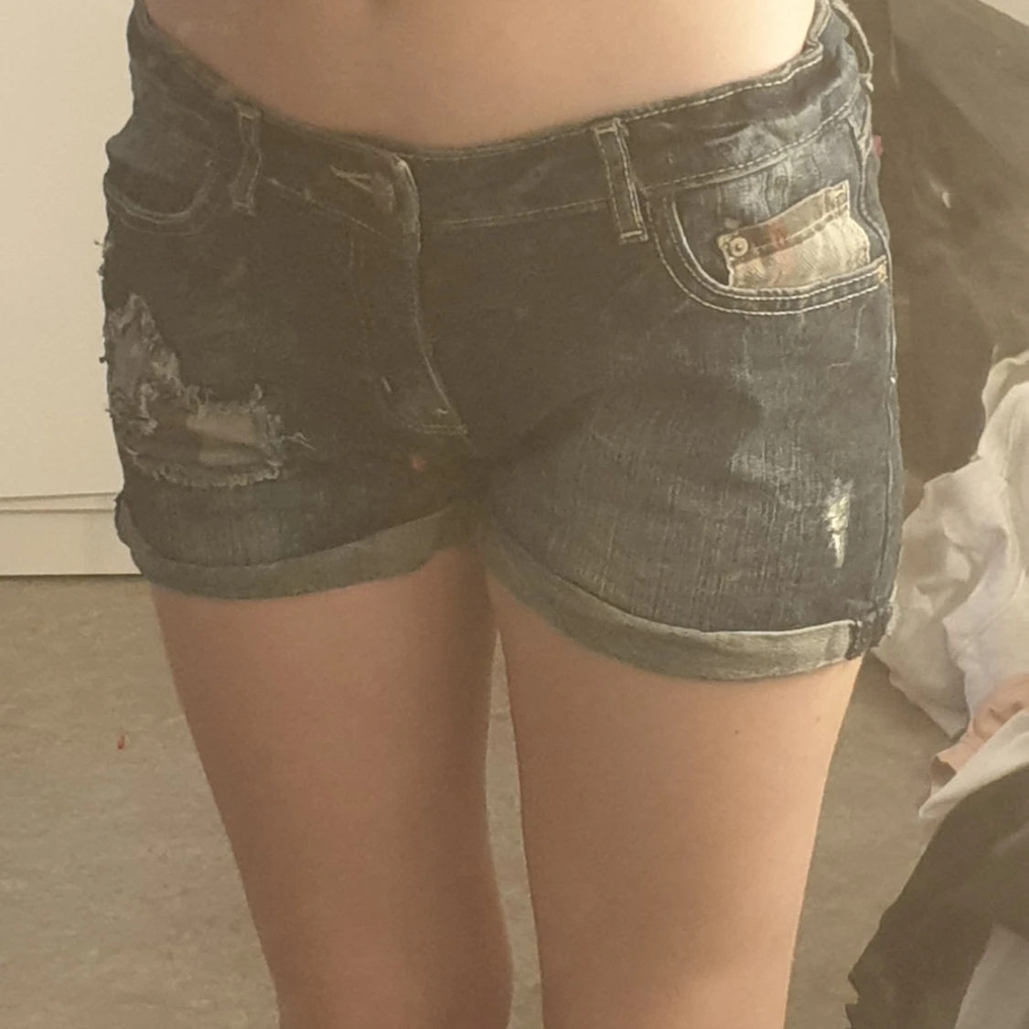 Ett par lågmidjade jeans shorts