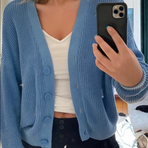 Stradivarius stickad blå kofta  - V-ringad stickad ljusblå kofta (första bilden visar rätt färg, kameran gjorde färgen ljusare på andra) från Stradivarius i bomull. Köpt för 2 år sedan (260kr) men inte använts mycket och är fortfarande i bra skick!