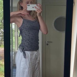 Festtopp strl S - Festtopp med häftigt mönster och knytdetalj i sidan. Svart/grå/guldigt. Strl S. Sitter fint och bekvämt! Fungerar bra till jeans eller kjol. Fint skick, aldrig använt.