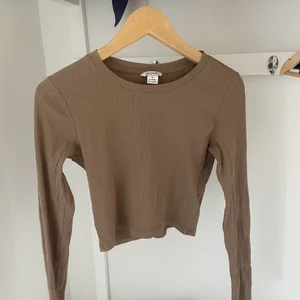 Långarmad kort tröja  - En kort beige tröja från monki  Den är ribbad 
