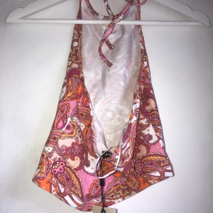 Rygglös linne  - Oanvänt Linne med snöre i nacken, öppen rygg och sommrigt mönste från bikbok. 