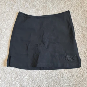 UNIF miniskirt med broderad drake - Säljer min Supersöta miniskjol importerad från USA och märket UNIF. Endast prövad och är i toppen skick. Har inbyggda shorts vilket är lite för trånga för mig (strl 38) passar nog en storlek 36 bra. 